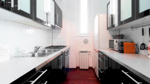 uma cozinha branca com um lavatório e um fogão em Italianway - Nona Strada 7 em Segrate