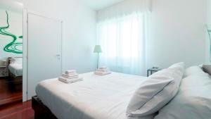 a bedroom with a bed with white sheets and pillows at Italianway - Nona Strada 7 in Segrate