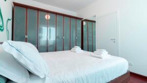um quarto com uma grande cama branca e uma parede de vidro em Italianway - Nona Strada 7 em Segrate