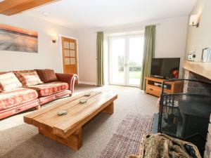 a living room with a couch and a coffee table at Ty Top in Llanfaethlu