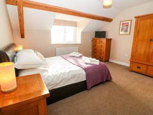 Ty Top في Llanfaethlu: غرفة نوم بسرير وخزانة وطاولة