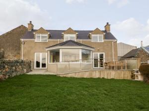 a house with a large deck and a patio at Ty Top in Llanfaethlu