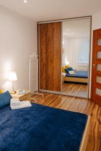 1 dormitorio con espejo grande y cama en Blue Holiday, en Łukęcin