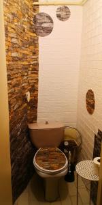 a bathroom with a toilet with a brick wall at Vieno kambario butas su balkonu in Kaunas