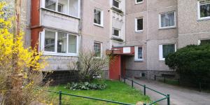 an apartment building with a yard in front of it at Vieno kambario butas su balkonu in Kaunas