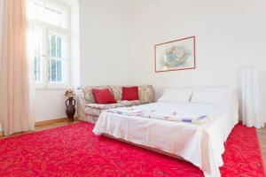 a bedroom with a white bed and a red rug at Apartment Red Coral in Dubrovnik