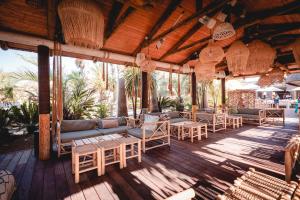 een patio met banken en stoelen op een houten terras bij Kon Tiki in Saint-Tropez