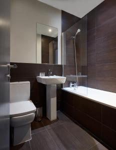 a bathroom with a sink and a toilet and a tub at Holborn by Viridian Apartments in London