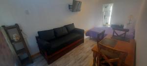 sala de estar con sofá y cama en ABBA Departamento turistico en Trevelín