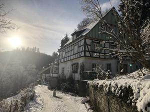 een huis in de sneeuw met de zon op de achtergrond bij Haus Onel in Schmallenberg
