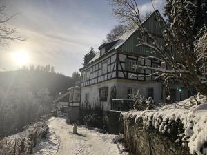 a house in the snow with the sun in the background at Haus Onel in Schmallenberg