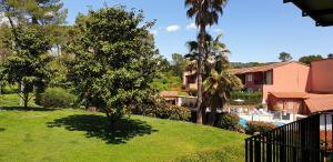 a view of a resort with a pool and trees at Studio meublé en face du golf côté piscine in Mouans-Sartoux