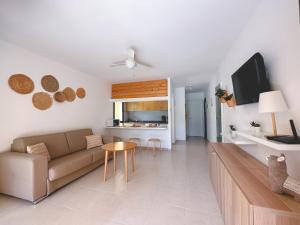 a living room with a couch and a table at Seaside Apartment Corralejo : A cozy holiday home in a peaceful well located green complex in Corralejo