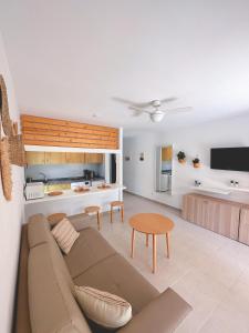 a living room and kitchen with a couch and a table at Seaside Apartment Corralejo : A cozy holiday home in a peaceful well located green complex in Corralejo