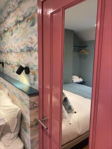 une porte rose dans une chambre avec 2 lits dans l'établissement Masonic Arms Gatehouse, à Gatehouse of Fleet