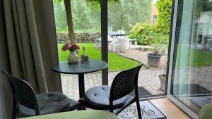 een patio met een tafel en stoelen en uitzicht op een tuin bij Be-B in Wageningen