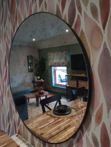 un miroir reflétant un salon avec une table dans l'établissement Masonic Arms Gatehouse, à Gatehouse of Fleet