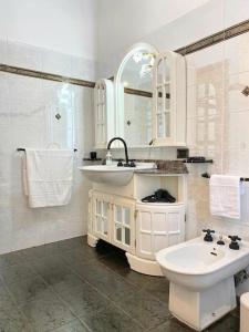 Baño blanco con lavabo y aseo en CasaEtnaMarty Acireale, en Acireale