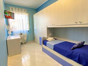 Dormitorio azul con cama y lavamanos en CasaEtnaMarty Acireale, en Acireale