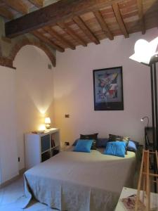 a bedroom with a large bed with blue pillows at IL PICCOLO EDEN - Private Garden in Livorno