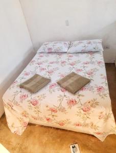 1 cama con 2 almohadas en una habitación en Chalés do Inglês, en Ilhabela