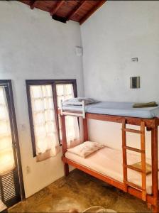 um quarto com 2 beliches e 2 janelas em Chalés do Inglês em Ilhabela