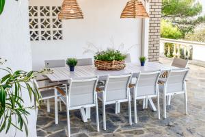 a white table and chairs on a patio with plants at View Villa in Skiathos