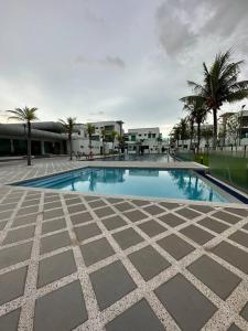 a large swimming pool with palm trees and buildings at Ulike~home stay~Setia residen~4room in Kampong Selamat