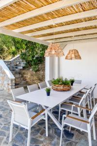 a white dining table and chairs on a patio at View Villa in Skiathos