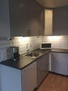 a kitchen with a sink and a microwave at Fräsch marklägenhet strax utanför Torekov! in Båstad +1 photo