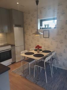 a kitchen with a table and chairs in a room at Nybyggd marklägenhet strax utanför Torekov! in Båstad