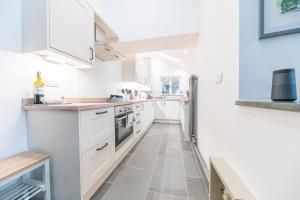a kitchen with white cabinets and a tile floor at Bend or Bump Coniston in Coniston