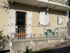 a balcony with white doors and a chair on a building at Charmant T2 in Aix-les-Bains