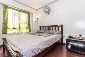 1 dormitorio con 1 cama y reloj en la pared en BUDER TownHouse Lias Marilao Bulacan Philippines, en Marilao