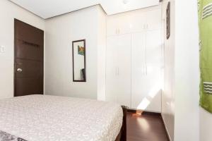 a white bedroom with a bed and a window at BUDER TownHouse Lias Marilao Bulacan Philippines in Marilao