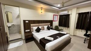 a bedroom with a large bed and a bathroom at UR Residency New BEL ROAD in Bangalore