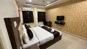 une chambre d'hôtel avec un lit et une télévision dans l'établissement UR Residency New BEL ROAD, à Bangalore