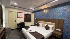 a bedroom with a large bed and a desk at UR Residency New BEL ROAD in Bangalore