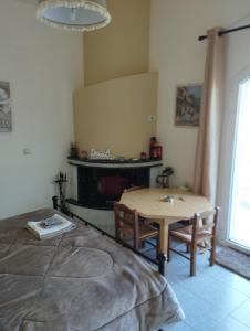 - un salon avec une table et une cheminée dans l'établissement Relaxing Home Monthly, à Akraífnion