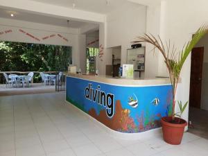 a restaurant with a diving counter with a potted plant at Jalyn's Resort Sabang in Puerto Galera