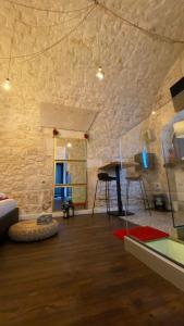 un soggiorno con un muro in pietra e un tavolo di Suite117 a Ostuni