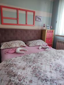 a bedroom with a bed with two dolls laying on it at Stan na dan Pale Apartman Danica in Pale