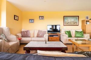 uma sala de estar com dois sofás e uma televisão em 5 bedrooms house at Liencres 50 m away from the beach with sea view sauna and enclosed garden em Liencres