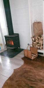 una estufa de leña en una habitación con una cesta de leña en Stormyrens semesterboende Villa 2 en Rättvik
