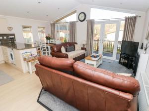 uma sala de estar com um sofá de couro castanho em Tranquillity em Narberth