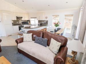uma sala de estar com um sofá e uma cozinha em Tranquillity em Narberth