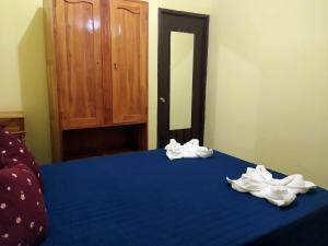 - un lit bleu avec des serviettes blanches dans l'établissement Guest House Los Corredores del Castillo, à Granada