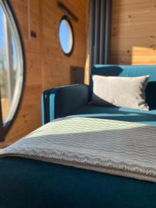 Powder Mill في Ponsanooth: غرفة نوم بسرير ازرق ونافذة دائرية