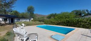 una piscina con un grupo de sillas al lado en Casa Condal, en Villa General Belgrano