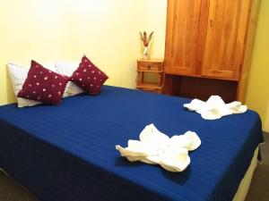 Una cama azul con toallas blancas. en Guest House Los Corredores del Castillo, en Granada